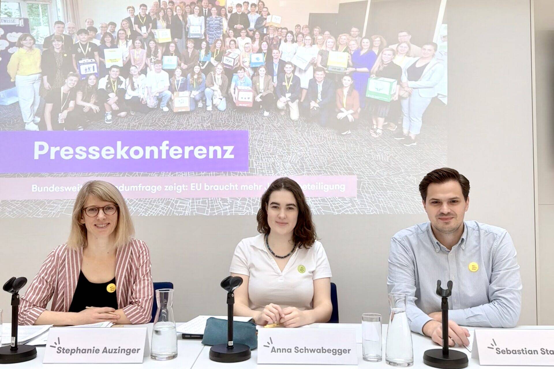 Das Bild zeigt drei Personen auf dem Podium einer Pressekonferenz zu den Ergebnisse der Umfrage 