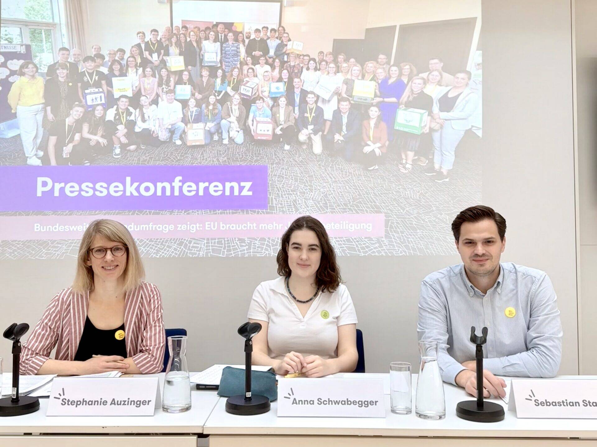 Das Bild zeigt drei Personen auf dem Podium einer Pressekonferenz zu den Ergebnisse der Umfrage 