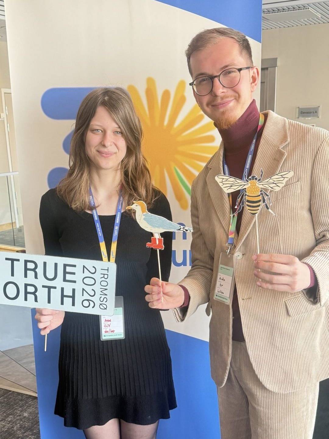 Europäische Jugenddelegierte stehen vor Plakat in Tromso